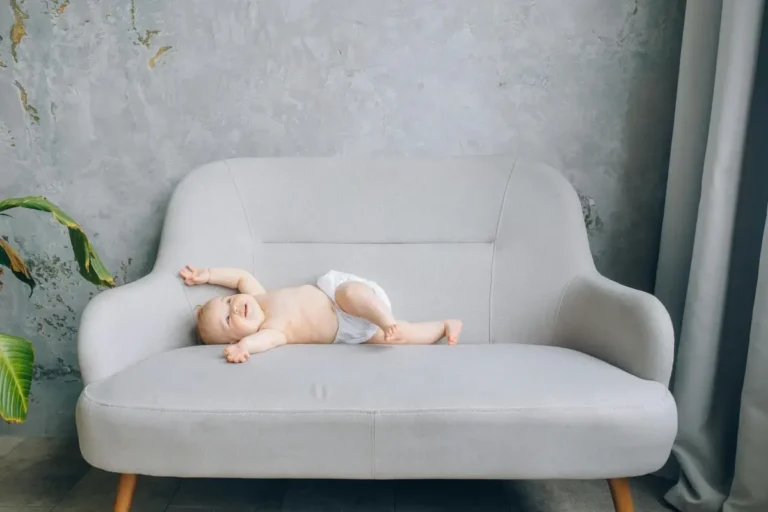 Minimalisme et maternité : un bébé joue sur un canapé